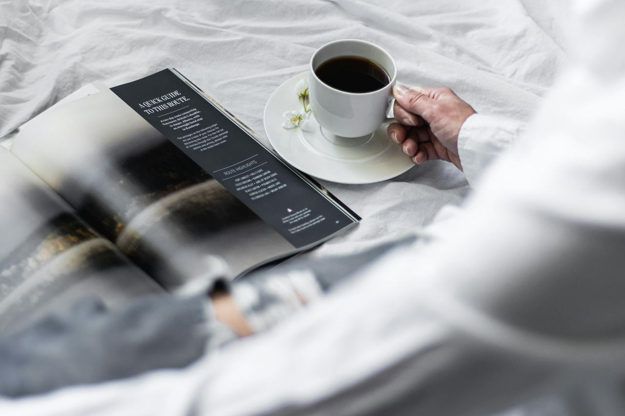 A serene morning scene with black coffee and a magazine, perfect for relaxation.